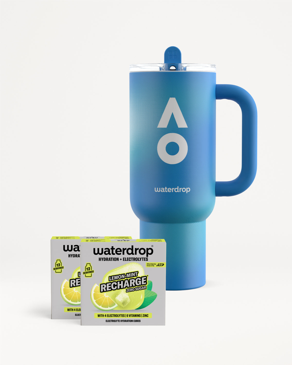 Cană termos albastră waterdrop cu mâner și capac, lângă două cutii Recharge Lemon-Mint fără zahăr, fiecare cu 12 porții, pe fundal alb.