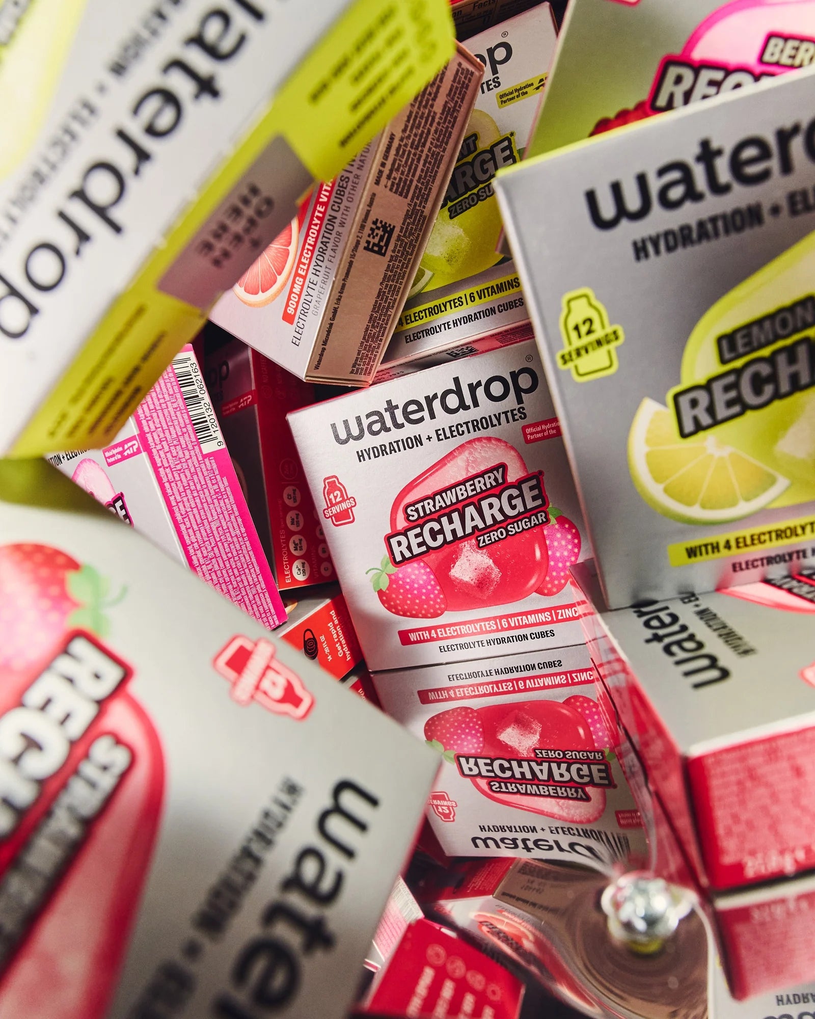 Cutii asortate waterdrop Recharge cu cuburi de hidratare, în diferite arome, așezate strâns, inclusiv Strawberry și Lemon-Mint.
