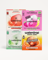 Patru cutii Microdrink Waterdrop cu aromele Grapefruit, Pink Lemonade, Frosted Lime și Cola Orange, așezate pe fundal alb.