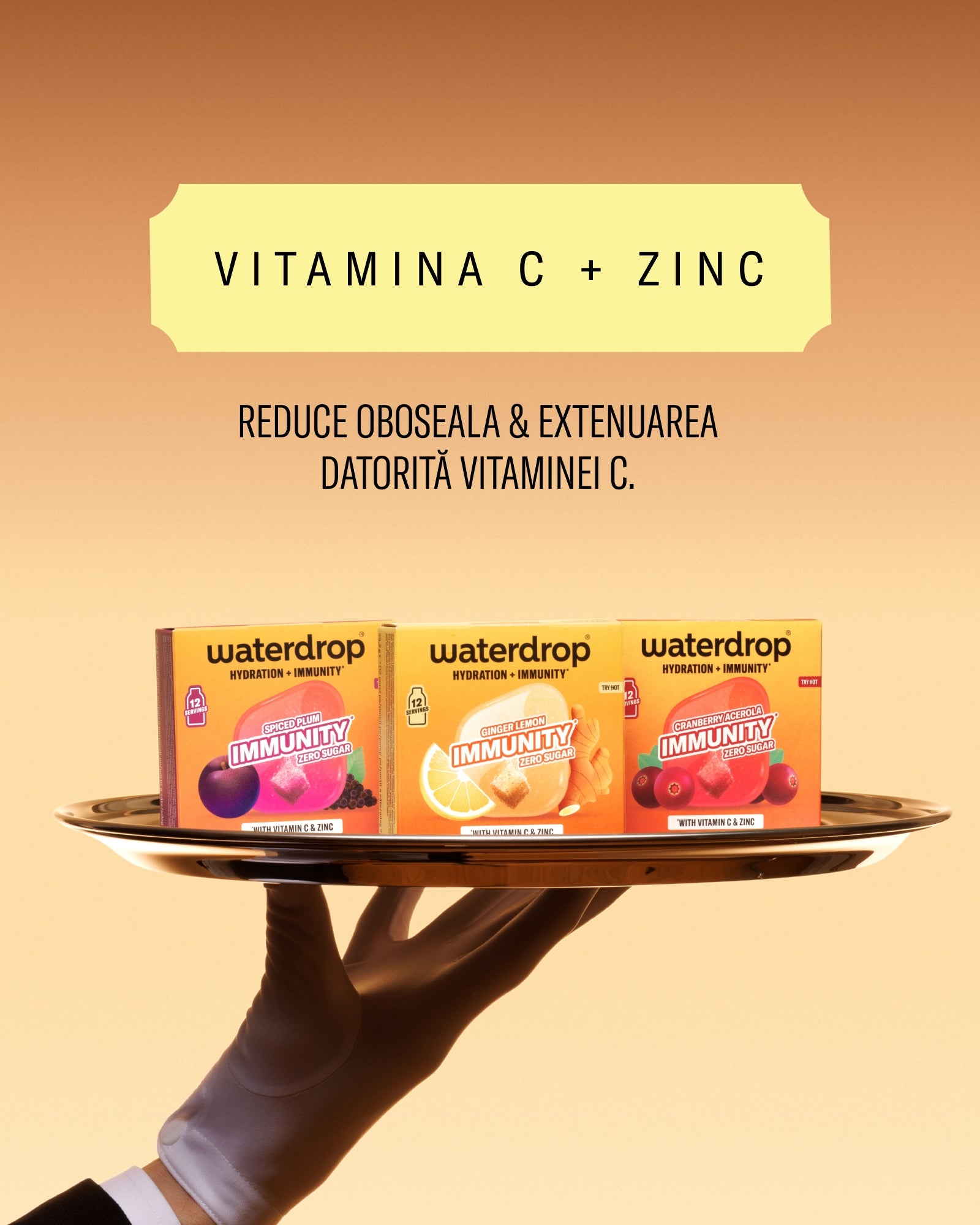 O mână ține o tavă rotundă cu trei cutii de suplimente Vitamina C și zinc pe un fundal orange în gradient.